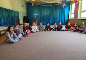Dzieci siedzą w kręgu i słuchają informacji o niedźwiedziach polarnych