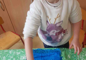 Dziewczynka przy użyciu wałka plastycznego przygotowuje tło