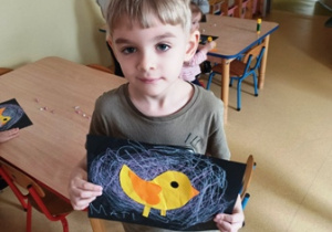 Mateusz prezentuje przygotowaną pracę plastyczną