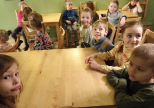 Dzieci siedzą przy stole i czekają na słodki poczęstunek w Baśniowej Kawiarence
