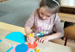 dziewczynka robi ślimaka z kół origami