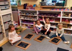 Układania na przygotowanych podkładkach litery M - inicjału Marii Montessori