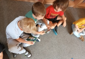 Dzieci oglądają zdjęcia jubilatki z rożnych etapów życia