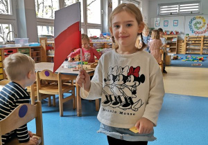 Dziewczynka pozuje z wykonaną przez siebie flagą