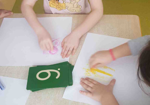 Dziewczynka rozpoczyna pracę odbijając cyfrę z papieru ściernego