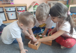 Dzieci w czasie pracy z cylindrami i kolorowymi walcami