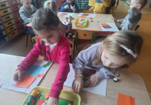 Dziewczynki w czasie pracy plastycznej z wykorzystaniem kwadratów