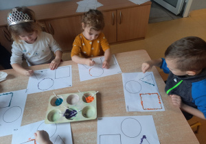 Dzieci w czasie stemplowania figur geometrycznych
