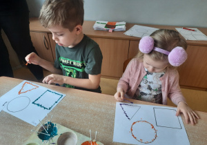 Gabryś i Laura w czasie stemplowania figur geometrycznych