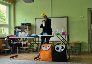 Pani pokazuje eksperyment z balonem