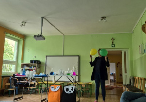Pani pokazuje eksperyment z balonem