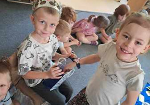 Dziewczynka po złożeniu życzeń wyjmuje cukierka z torby prezentowej