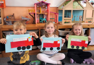 dzieci prezentują swoje wozy strażackie