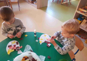 Dzieci młodsze przyklejają elementy pracy