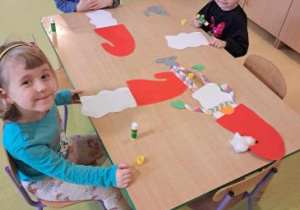 Dzieci siedzą przy stoliku i wykonują swoje skrzaty