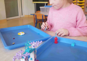 Dziewczynka bawi się klockami Lego