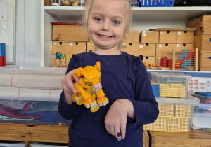Dziewczynka pozuje do zdjęcia z klockami Lego