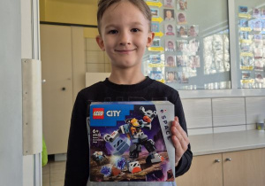 Chłopiec pozuje do zdjęcia z klockami Lego