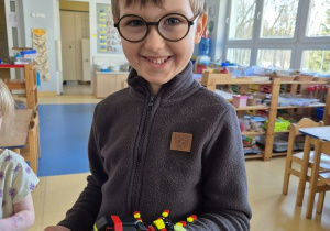 Chłopiec pozuje do zdjęcia z klockami Lego
