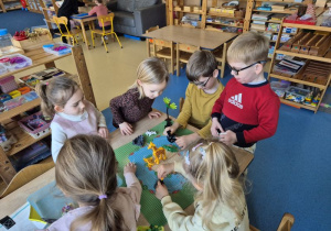 Dzieci budują z klocków Lego siedząc przy stoliku
