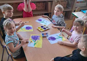 Dzieci przy stoliku podczas wykonywania pracy plastycznej przedstawiającej hiacynta