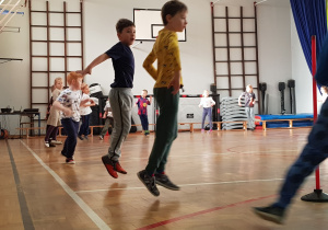 Dzieci podczas biegu rozgrzewkowego dookoła sali