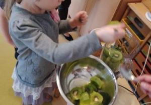 Zosia wkłada kiwi do blendera