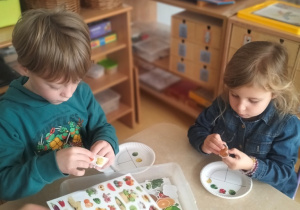 dzieci naklejają naklejki ze zdrową żywnością na papierowe talerzyki