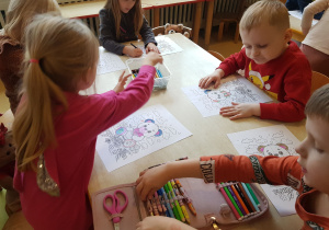 Dzieci kolorują obrazki z misiem