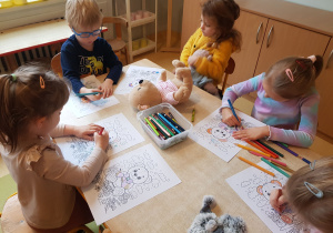 Dzieci kolorują obrazki z misiem