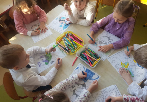 Dzieci kolorują obrazek z pingwinem