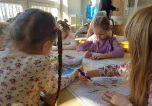 Dzieci kolorują obrazek z pingwinem