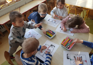 Dzieci kolorują obrazek z pingwinem