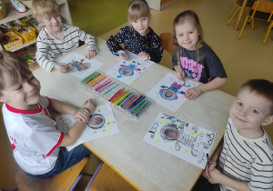 Dzieci rysują pracę plastyczną: ,,Lot w kosmos".