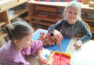 Zosia z Julą malują farbami słońce ze zgniecionego papieru