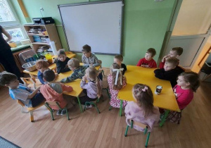 Dzieci podczas warsztatów badają strukturę mleka kokosowego