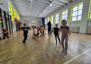 Dzieci biegają oraz wykonują rzut piłką