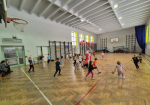 Dzieci biegają oraz wykonują rzut piłką