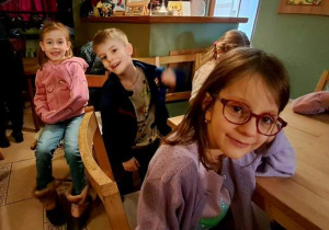 Dzieci siedzą na krzesełkach i czekają na rozpoczęcie przedstawienia pt. "Siedem koźlątek" w "Baśniowej Kawiarence"