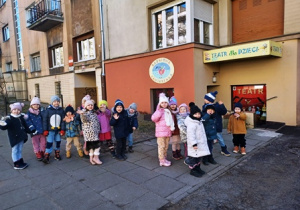 Dzieci stoją w parach przed budynkiem Baśniowej Kawiarenki