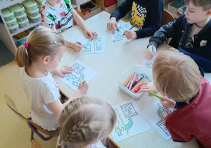 Dzieci kolorują pracę o tematyce ekologicznej.
