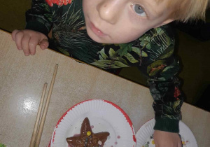Chłopiec kończy dekorować piernika