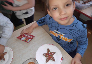 Chłopiec prezentuje ozdobione ciasteczko