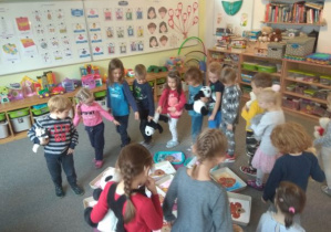 Dzieci oglądają wykonane przez siebie prace plastyczne pt. "Miś z kleksa"