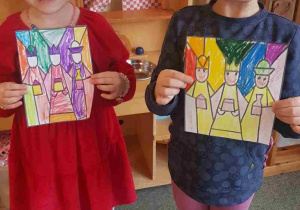 Dziewczynki pokazują swoje prace plastyczne z Trzema Królami