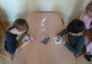 Chłopcy rysują mazakami na złożonych serwetkach