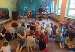 Dzieci słuchają utworu muzycznego granego na instrumencie