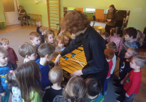 Dzieci przyglądają się z bliska instrumentowi muzycznemu