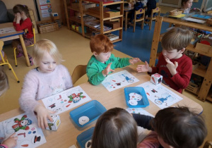 Dzieci w parach grają w gry siedząc przy stoliku