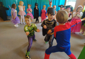 Trzech chłopców w strojach superbohaterów podczas tańca